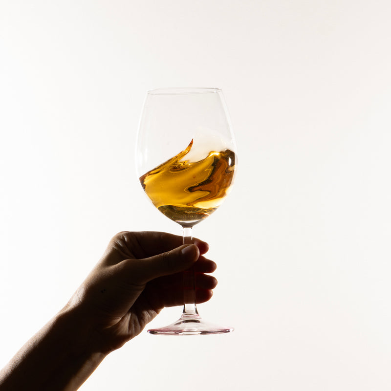 Hand holding a glass of Malamour Trebbiano white wine — Italian Abruzzo wine tasting
